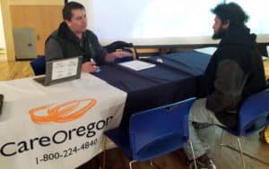 Karl Berry of CareOregon helps a guest. 