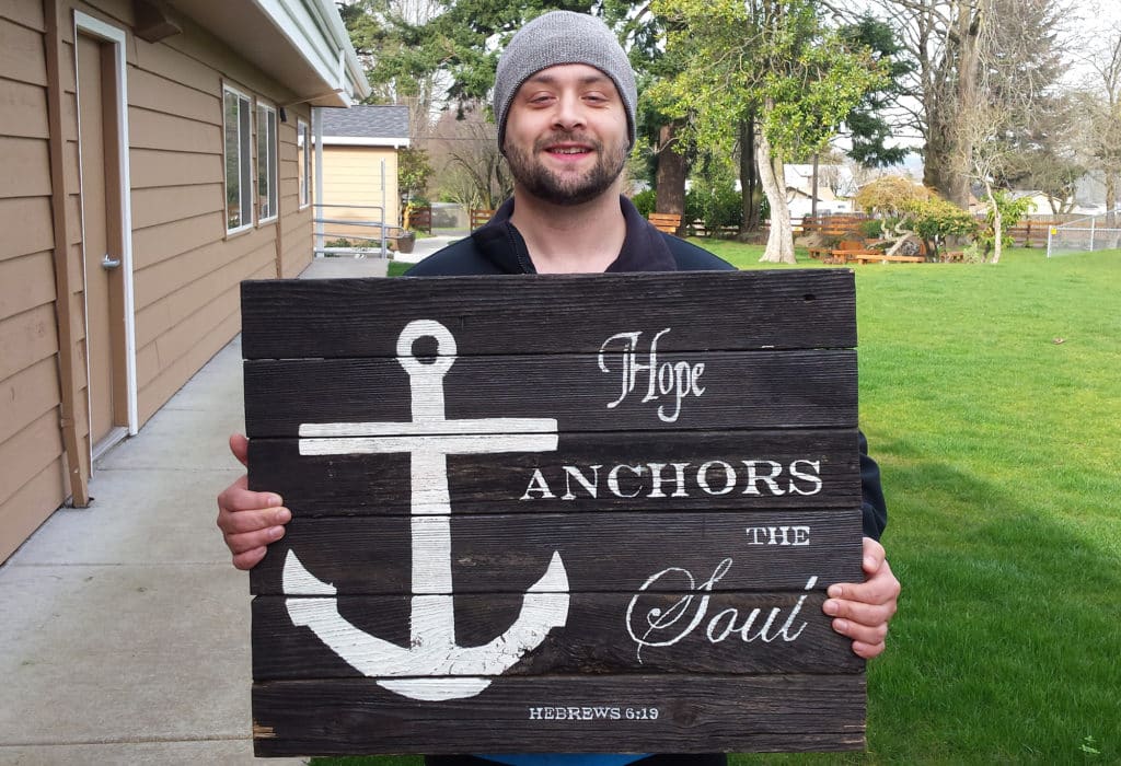 Kelcy holds one of The Harbor's main signs in the courtyard. 