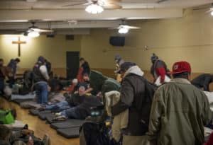 Guests file in to the Guest Care Center at the Burnside Shelter to sleep for the night.
